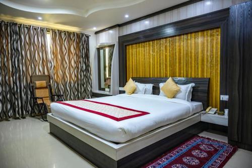 ein Schlafzimmer mit einem großen Bett in einem Zimmer in der Unterkunft Bodhgaya Regency Hotel in Bodh Gaya