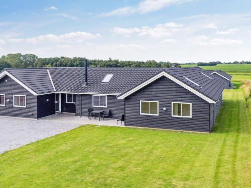 a black house with a large yard at 20 person holiday home in Stege in Stege