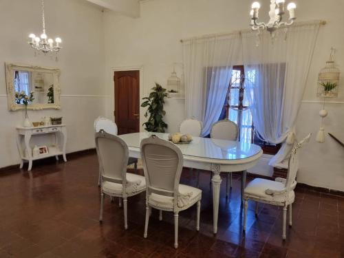 a dining room with a white table and chairs at White House - Hospedaje con Desayuno in La Rioja