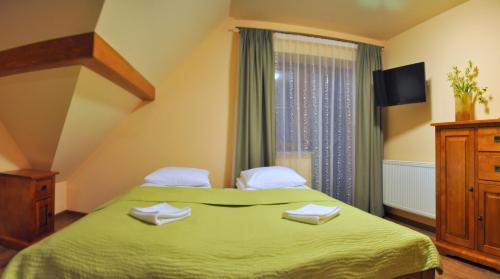 Un dormitorio con una cama verde y una ventana en Willa Ślązaczka en Wisła