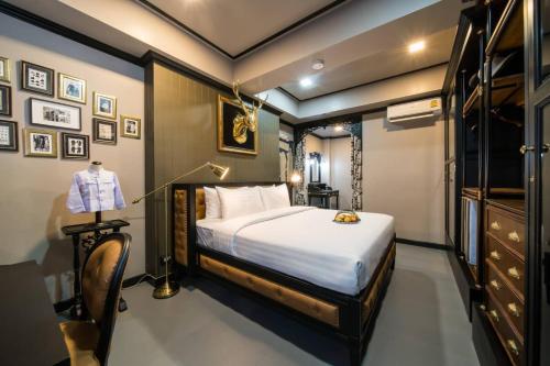 - une chambre avec un lit et une chaise dans l'établissement DE Phanakron Boutique Hotel, à Bangkok