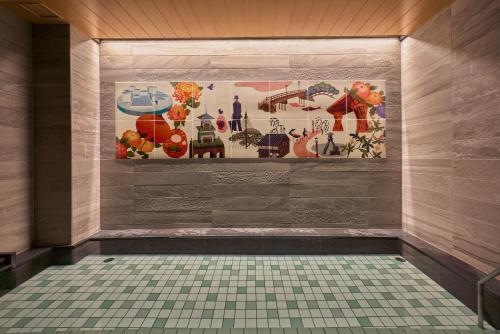 a bathroom with a tile floor and a painting on the wall at Hotel Intergate Kanazawa in Kanazawa