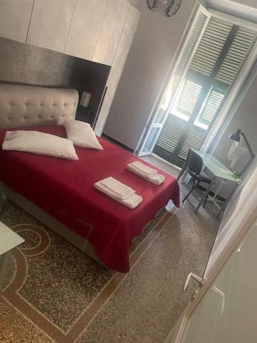 una camera da letto con un letto con lenzuola rosse e cuscini bianchi di Centro da Marco a Savona