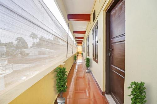 un pasillo vacío con macetas en un edificio en OYO Hotel Faizalia Tourist Home, en Perumpāvūr