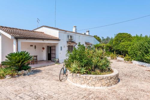 una casa blanca con patio y una bicicleta delante de ella en Carbone Country House Oria - Happy Rentals, en Oria