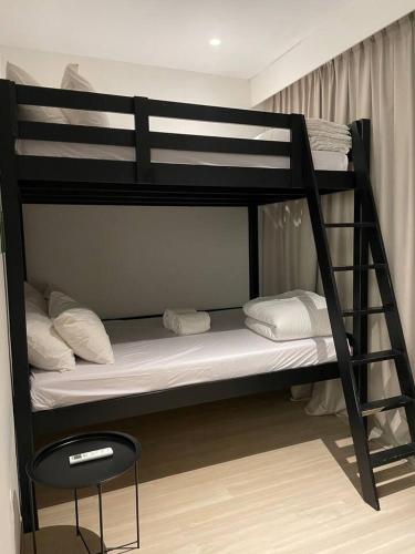 a black bunk bed with a chair in a room at Monde Residence K 01 Batam Centre in Nagoya