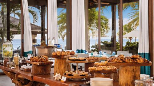a table with a buffet of bread and pastries at Zemi Beach House, LXR Hotels & Resorts in Shoal Bay Village