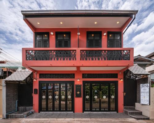 a red building with a balcony at DE Phanakron Boutique Hotel in Bangkok