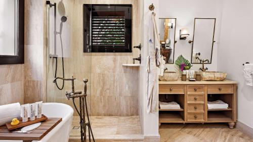 a bathroom with a sink and a toilet and a tub at Zemi Beach House, LXR Hotels & Resorts in Shoal Bay Village