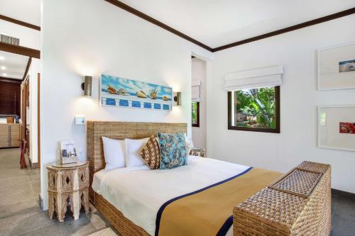 a bedroom with a large bed and a chair at Zemi Beach House, LXR Hotels & Resorts in Shoal Bay Village
