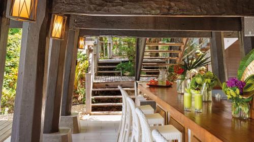 a wooden table and chairs on a porch with stairs at Zemi Beach House, LXR Hotels & Resorts in Shoal Bay Village