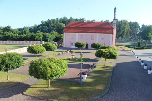 a park with trees and a building with a red roof at Liškiavos vienuolyno ansamblis in Liškiava