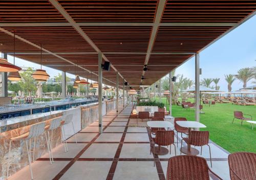 an outdoor patio with tables and chairs and a bar at Maxx Royal Belek Golf Resort in Belek