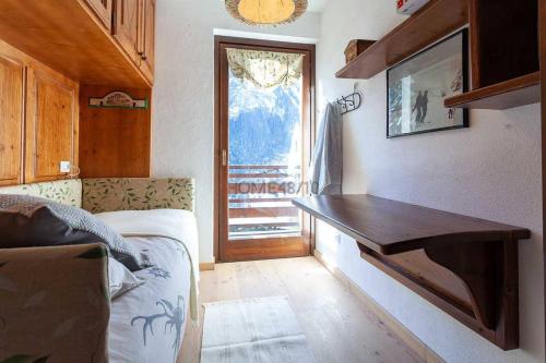 a room with a wooden desk in a room with a window at Courmayeur~navetta gratuita per il centro+impianti in Courmayeur