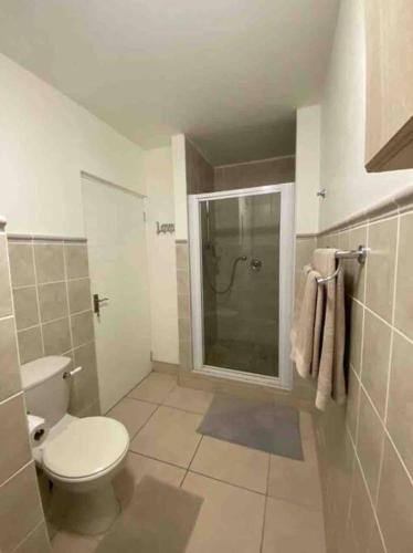 a bathroom with a toilet and a shower in it at Unobstructed sea view gem (1 Spindrift) in St Francis Bay