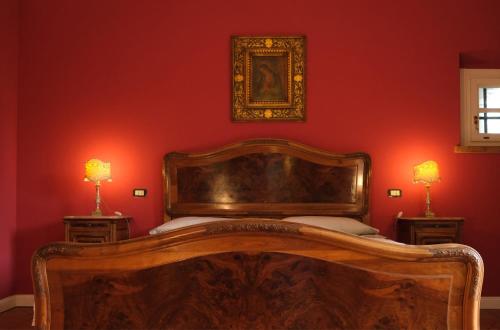 a bedroom with a wooden bed in a red wall at Villa Hélène in Solto Collina