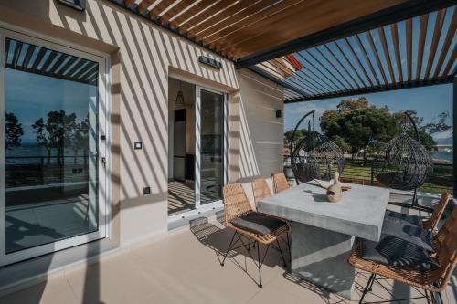 a patio with a table and chairs on a balcony at Ponte Suites in Antirrio