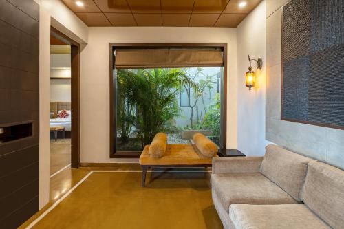 a living room with a couch and a large window at Mahua Bagh Resort Kumbhalgarh in Kumbhalgarh