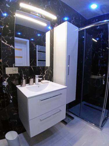 a bathroom with a white sink and a shower at Apartament Bieszczadzka A 8 Lesko in Lesko