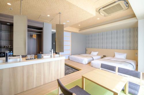 a hotel room with two beds and a kitchen at Tosei Hotel Cocone Tsukiji Ginza Premier in Tokyo