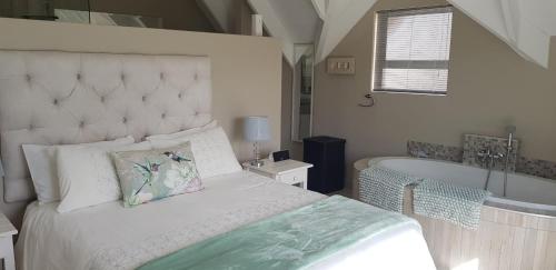 un dormitorio con una cama y una bañera en Gorgeous St Francis Canal House, en St Francis Bay