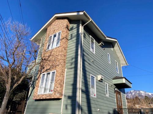 a house with a brick chimney on top of it at Greenwood Cottage Nikko in Nikko