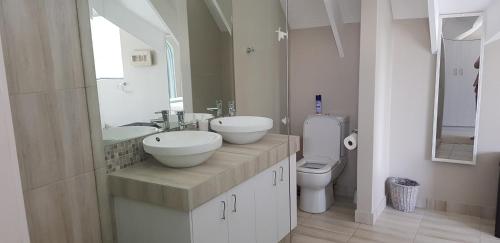 Un baño con dos lavabos y un inodoro. en Gorgeous St Francis Canal House, en St Francis Bay