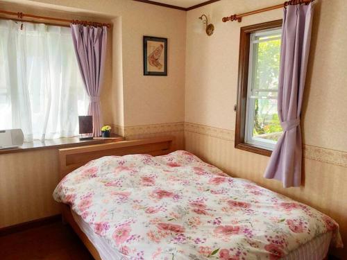 a bedroom with a bed and a window at Greenwood Cottage Nikko in Nikko