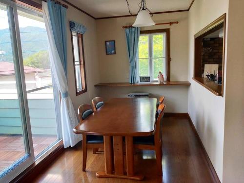 a dining room with a wooden table and chairs at Greenwood Cottage Nikko in Nikko