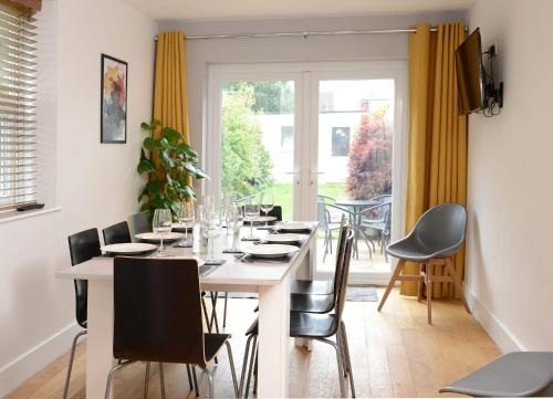 a dining room with a table and chairs and a window at Stylish and spacious Southampton stay in Southampton