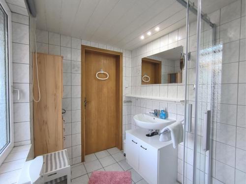 een badkamer met een wastafel en een spiegel bij Ferienwohnung Mohnkopf in Jerrishoe