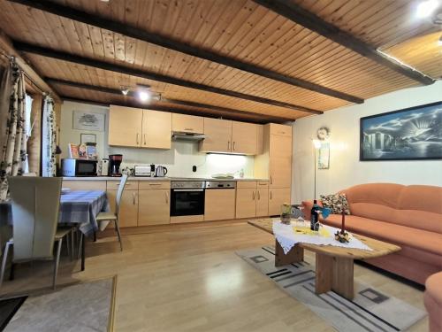een woonkamer en een keuken met een bank en een tafel bij Ferienwohnung Mohnkopf in Jerrishoe