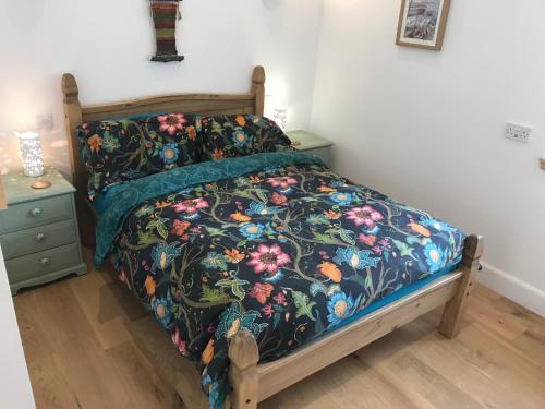 a bedroom with a bed with a floral comforter at The Old School, Kingussie in Kingussie