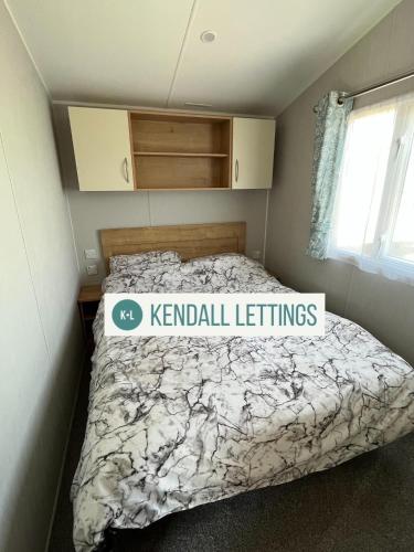 a bedroom with a bed with a sign on it at Willerby (Green Lawns) in Selsey