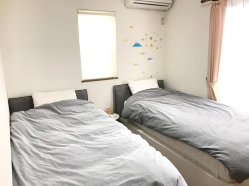 two beds sitting next to each other in a bedroom at Marine House - Vacation STAY 77620v in Koshigoe