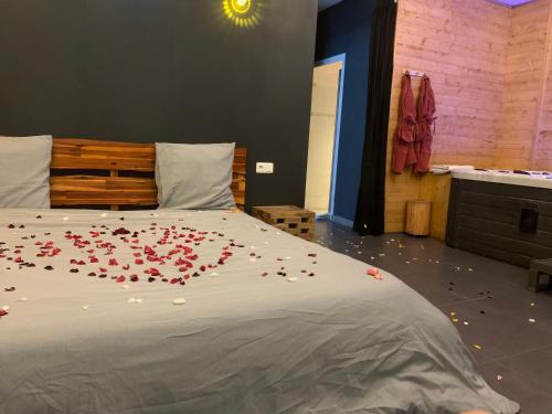 a bedroom with a bed with red rose petals on it at Diane Luxury 1 in Roubaix