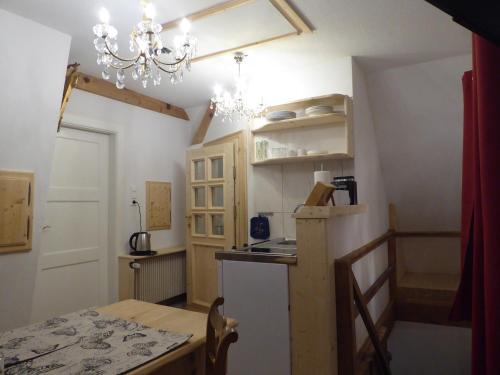 a small kitchen with a table and a chandelier at Pension Zur Rose in Weil am Rhein