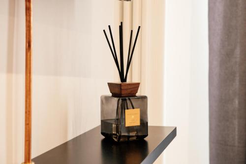 a glass vase with sticks in it sitting on a table at Bed and Breakfast Le Foglie in Altamura