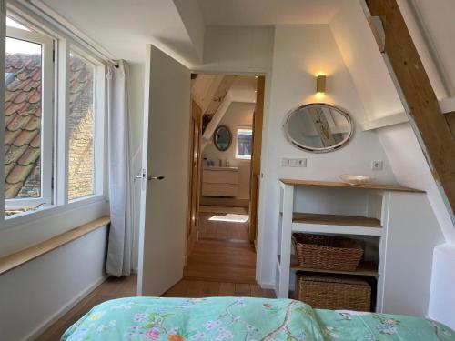 a room with a bed and a hallway with a window at Het Heertje in Den Hoorn