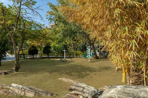 a park with a playground with trees and grass at Mahua Bagh Resort Kumbhalgarh in Kumbhalgarh