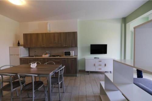 una cucina e una sala da pranzo con tavolo e sedie di Appartamenti Residence Tulipano a Sirmione