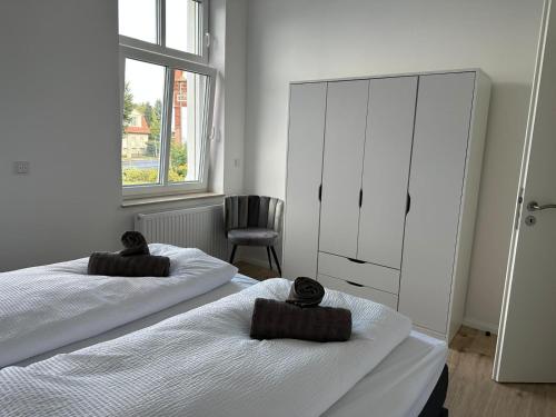 a bedroom with two beds and a dresser and a chair at Villa Schellhase in Werder