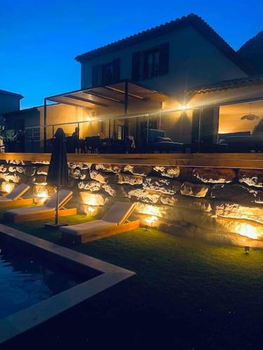 une maison éclairée à côté d'une piscine la nuit dans l'établissement Villa Azur, à La Valette-du-Var