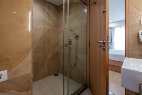 a shower with a glass door in a bathroom at GCC North Side in Mumbai