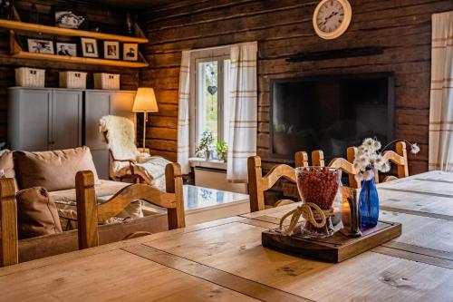 a living room with a table and a tv at Kotatuli Forest Lodge in Rovaniemi