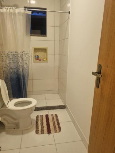 a bathroom with a toilet and a shower at Quarto duplo em Bacaxa in Saquarema