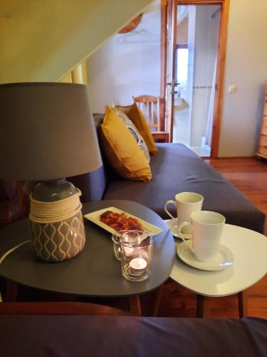 a table with two cups and a plate of food at Jaun-Ieviņas in Rauna