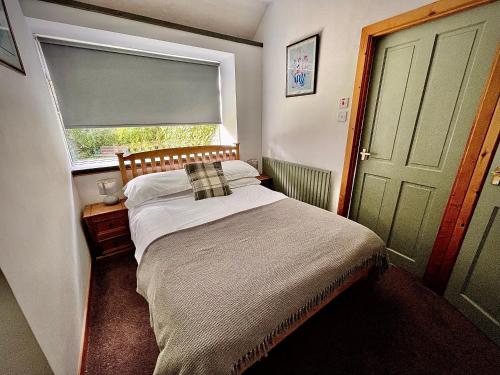 a small bedroom with a bed and a window at The Horseshoe in Lochgilphead
