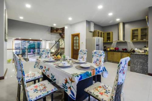 a dining room with a table and chairs and a kitchen at Patong Villa1三卧泳池别墅两个海景房 近班赞江西冷海滩中文管家 in Patong Beach