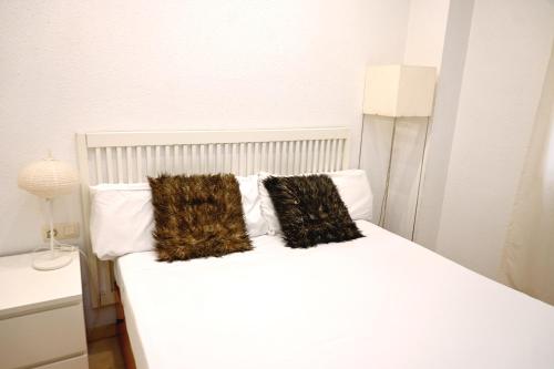 - un lit blanc avec 2 oreillers dans l'établissement Homenfun Barcelona Sagrada Familia Lepanto, à Barcelone